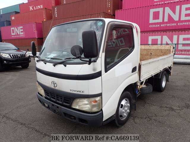 A grey JDM sports car speeding down a highway at night.