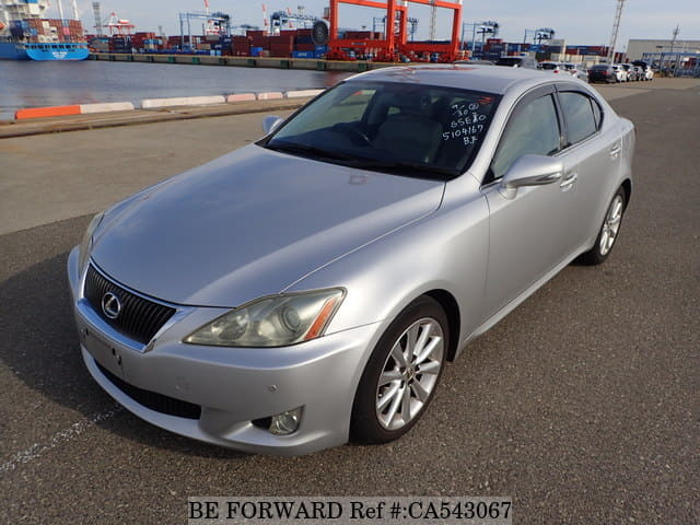 A grey JDM sports car speeding down a highway at night.