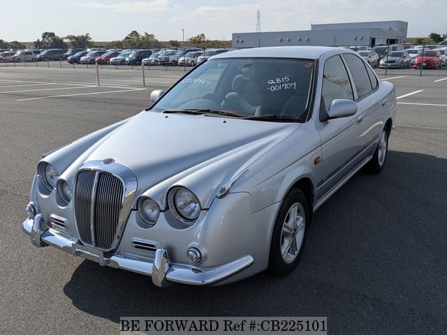 A grey JDM sports car speeding down a highway at night.