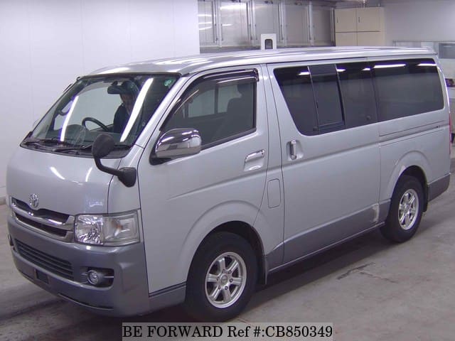 A grey JDM sports car speeding down a highway at night.