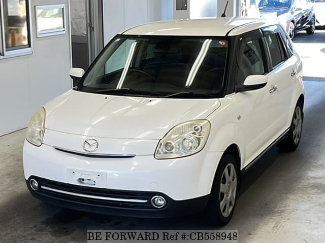 A grey sports car speeding down a highway at night.