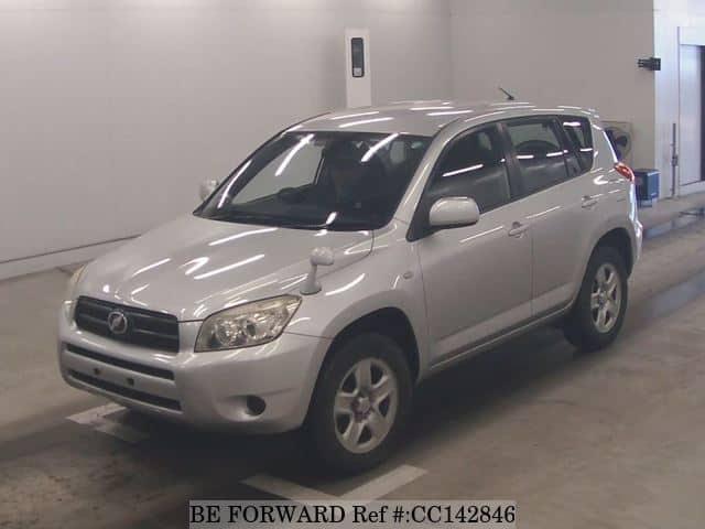 A grey sports car speeding down a highway at night.