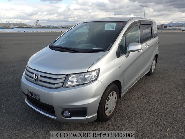 A grey sports car speeding down a highway at night.