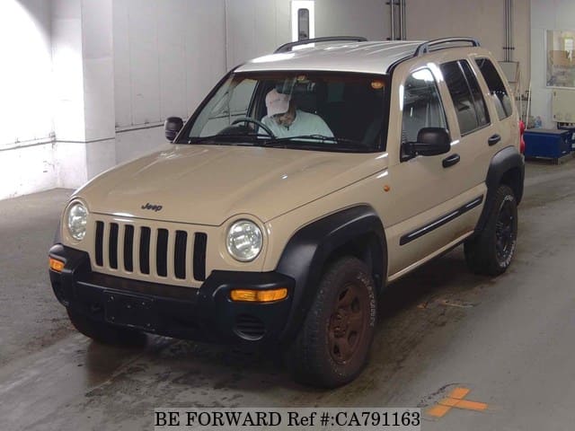 A grey JDM sports car speeding down a highway at night.