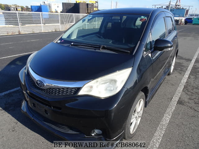 A grey JDM sports car speeding down a highway at night.