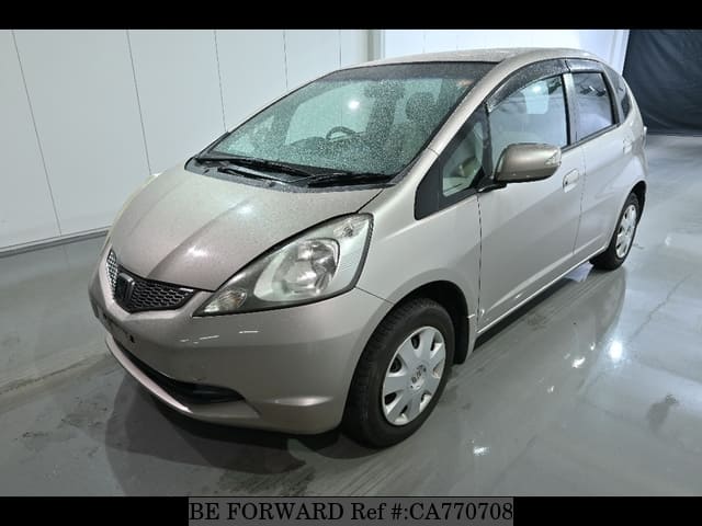 A grey JDM sports car speeding down a highway at night.