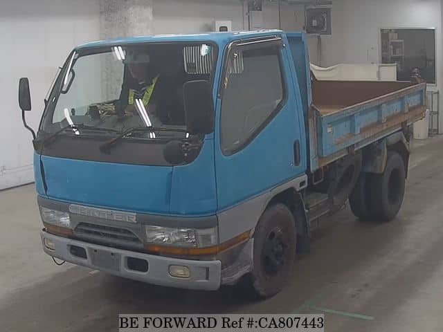 A grey JDM sports car speeding down a highway at night.