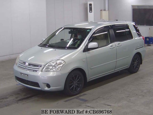 A grey JDM sports car speeding down a highway at night.