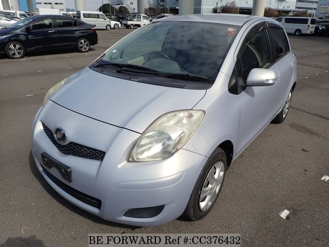 A grey sports car speeding down a highway at night.