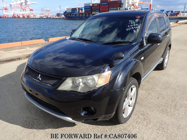 A grey JDM sports car speeding down a highway at night.