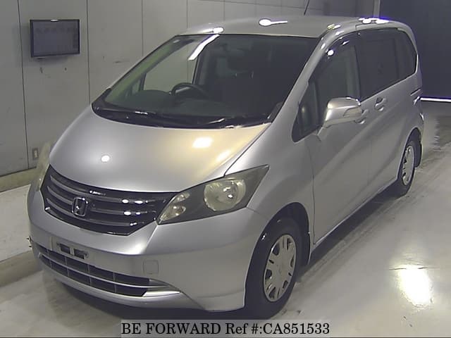 A grey JDM sports car speeding down a highway at night.
