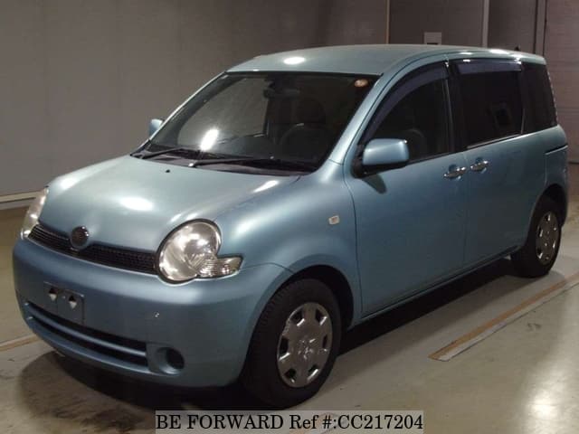 A grey sports car speeding down a highway at night.