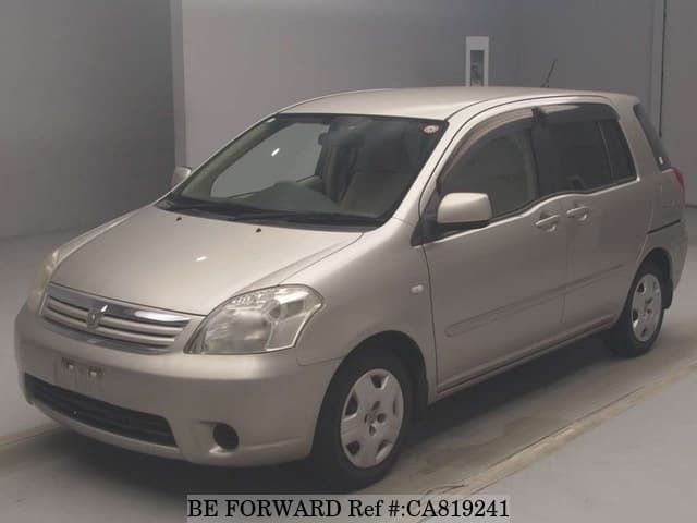 A grey JDM sports car speeding down a highway at night.