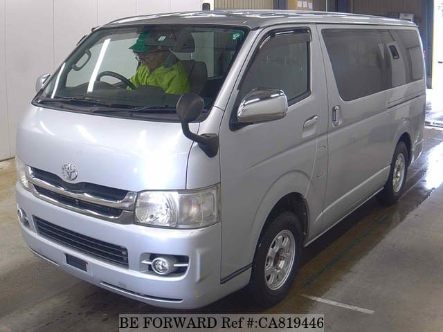 A grey JDM sports car speeding down a highway at night.