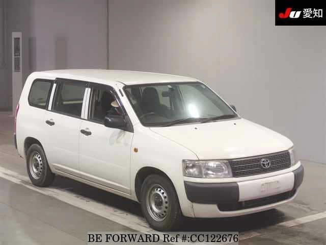 A grey sports car speeding down a highway at night.