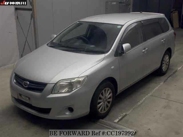 A grey sports car speeding down a highway at night.