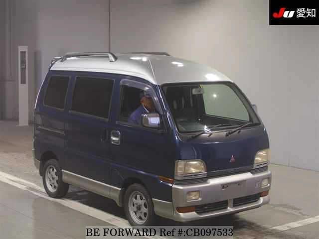 A grey JDM sports car speeding down a highway at night.
