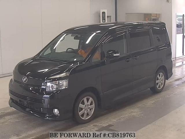 A grey JDM sports car speeding down a highway at night.