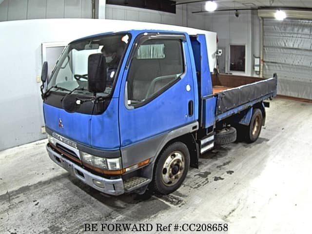A grey sports car speeding down a highway at night.