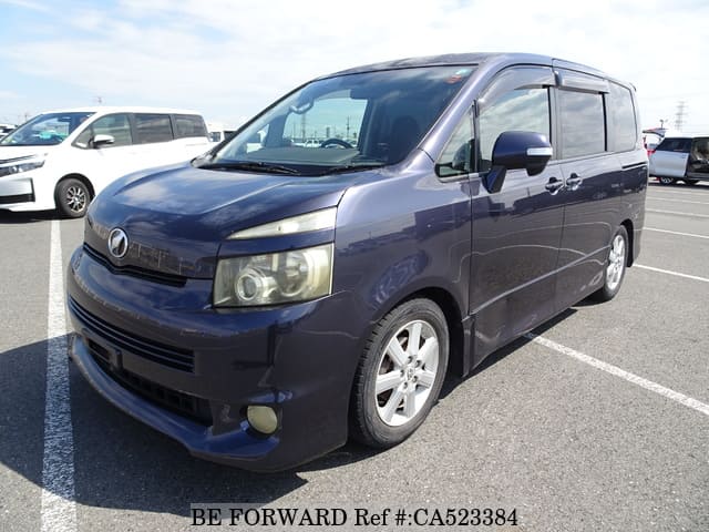 A grey JDM sports car speeding down a highway at night.