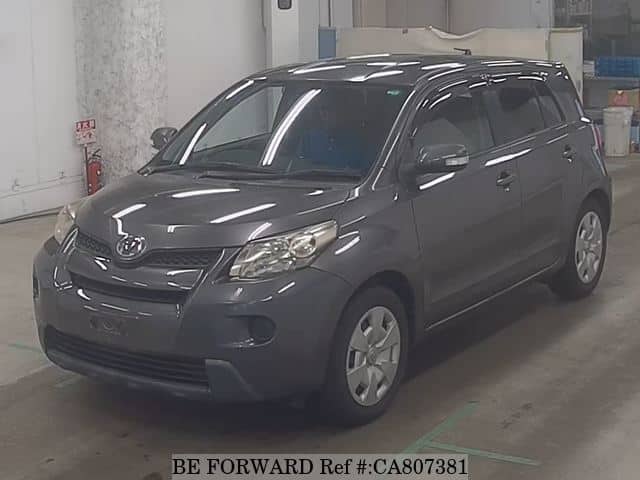 A grey JDM sports car speeding down a highway at night.