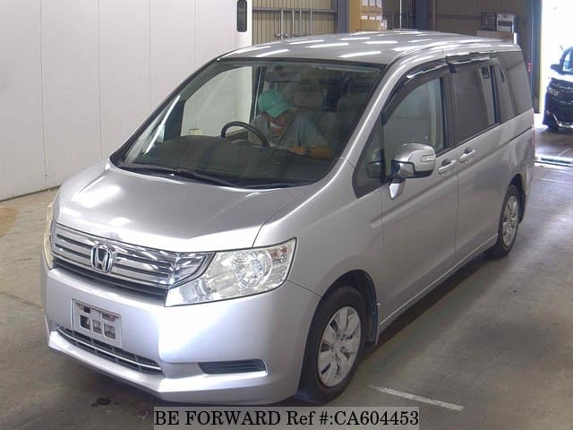A grey JDM sports car speeding down a highway at night.