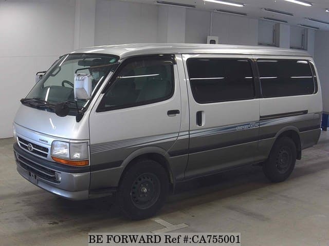 A grey JDM sports car speeding down a highway at night.
