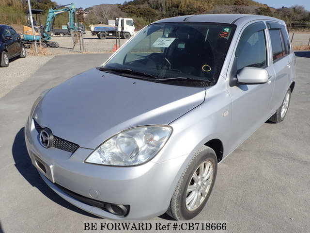 A grey JDM sports car speeding down a highway at night.