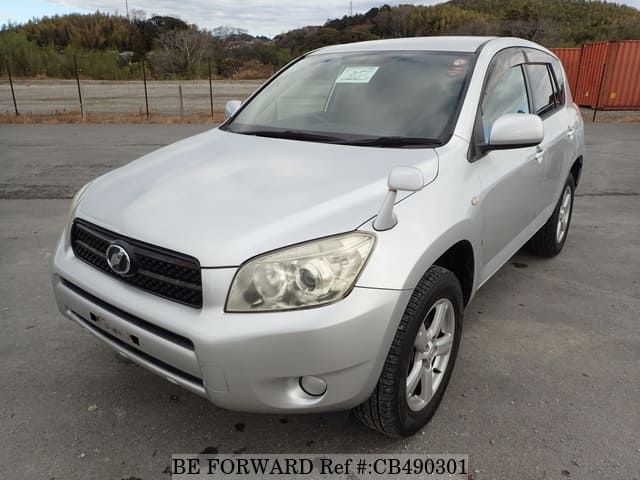 A grey JDM sports car speeding down a highway at night.
