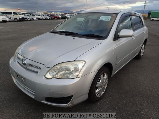 A grey JDM sports car speeding down a highway at night.