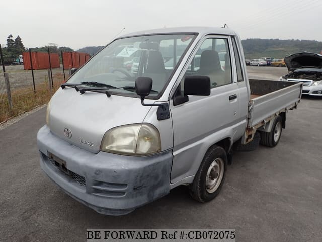 A grey JDM sports car speeding down a highway at night.