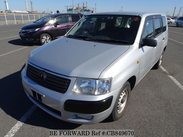 A grey sports car speeding down a highway at night.