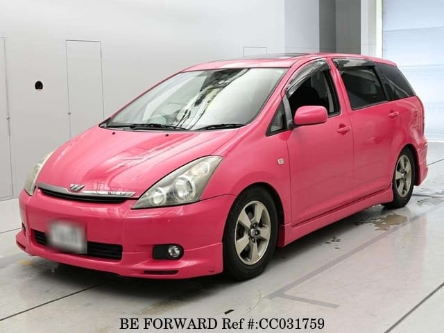 A grey sports car speeding down a highway at night.