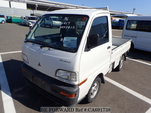A grey JDM sports car speeding down a highway at night.