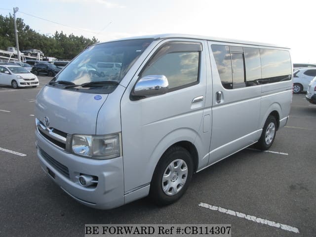 A grey JDM sports car speeding down a highway at night.