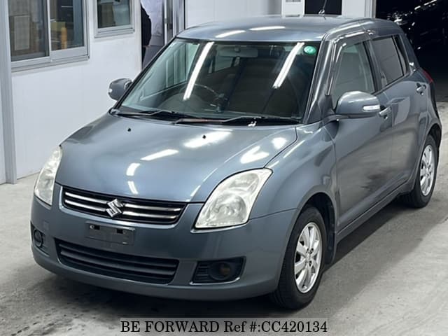 A grey JDM sports car speeding down a highway at night.
