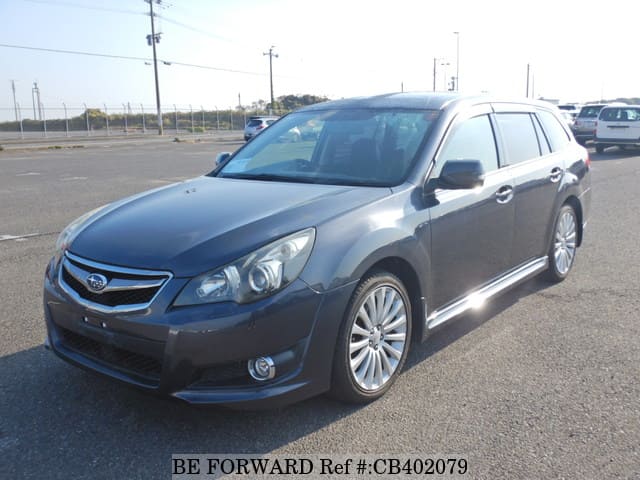 A grey JDM sports car speeding down a highway at night.