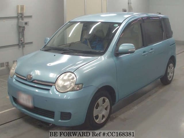 A grey sports car speeding down a highway at night.