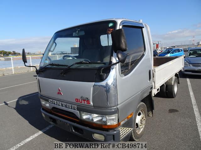 A grey JDM sports car speeding down a highway at night.