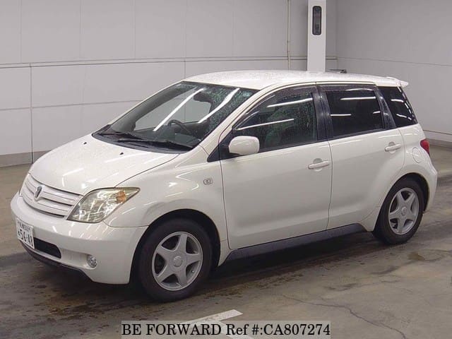 A grey JDM sports car speeding down a highway at night.