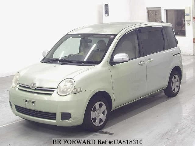 A grey JDM sports car speeding down a highway at night.