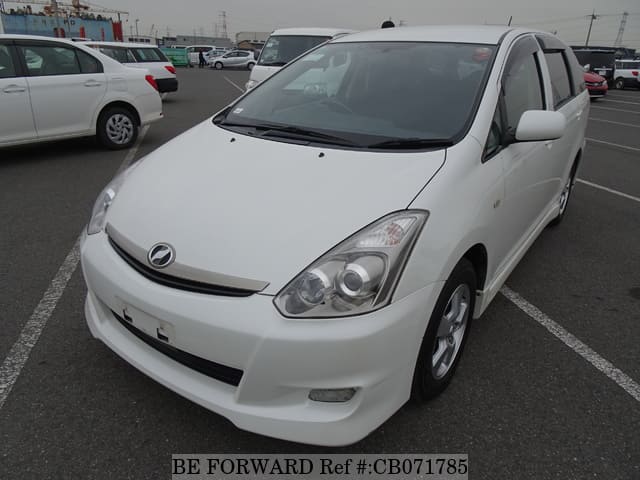 A grey JDM sports car speeding down a highway at night.