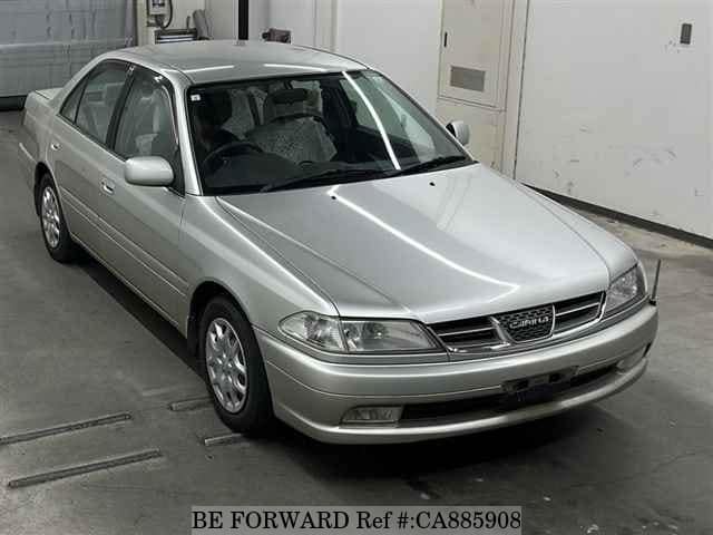 A grey JDM sports car speeding down a highway at night.