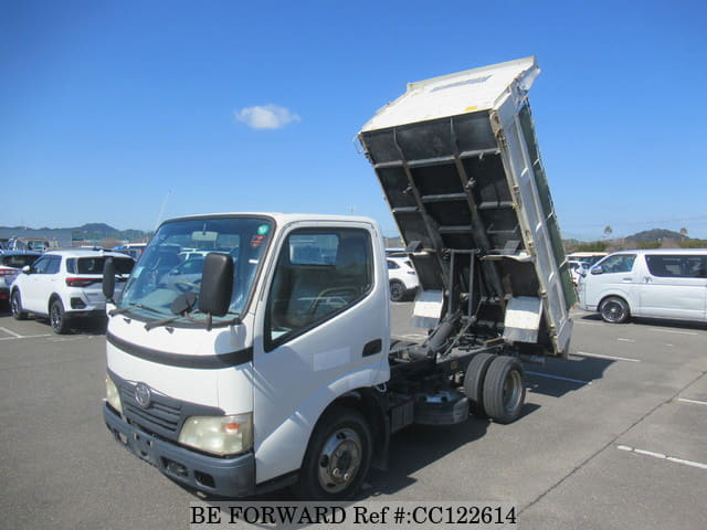 A grey sports car speeding down a highway at night.