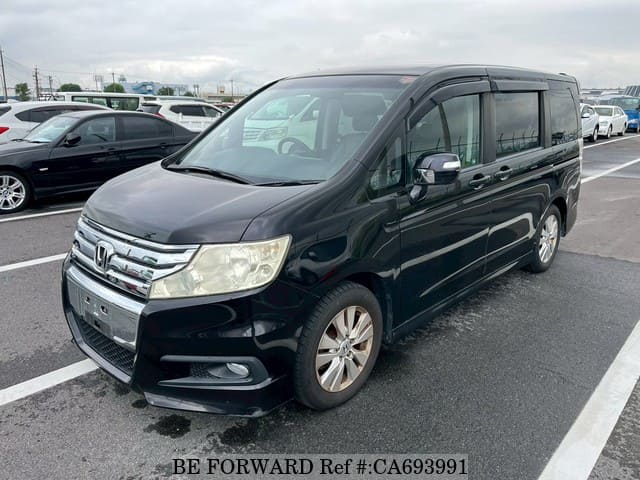 A grey JDM sports car speeding down a highway at night.