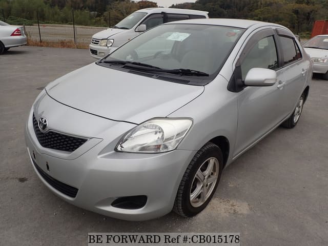 A grey JDM sports car speeding down a highway at night.