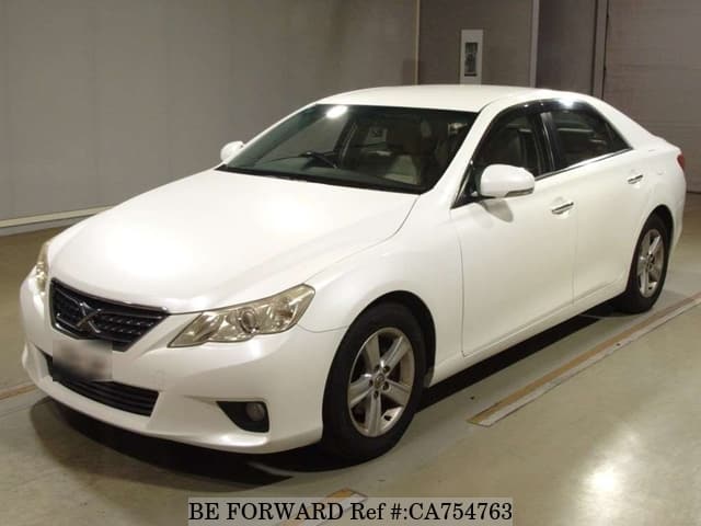 A grey JDM sports car speeding down a highway at night.