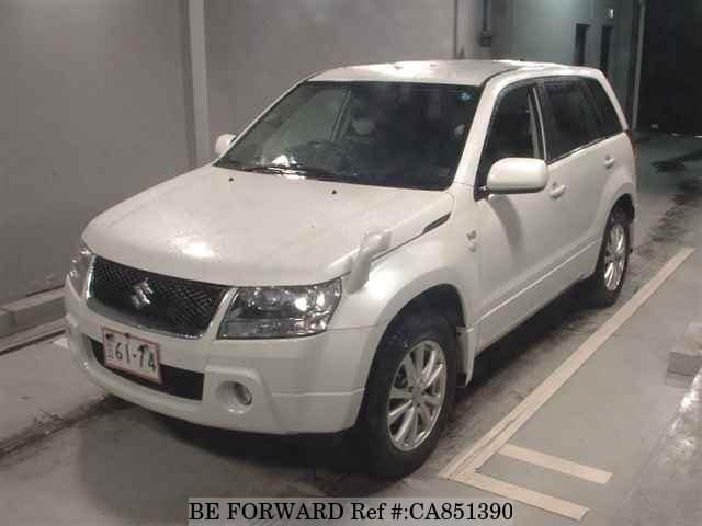 A grey JDM sports car speeding down a highway at night.