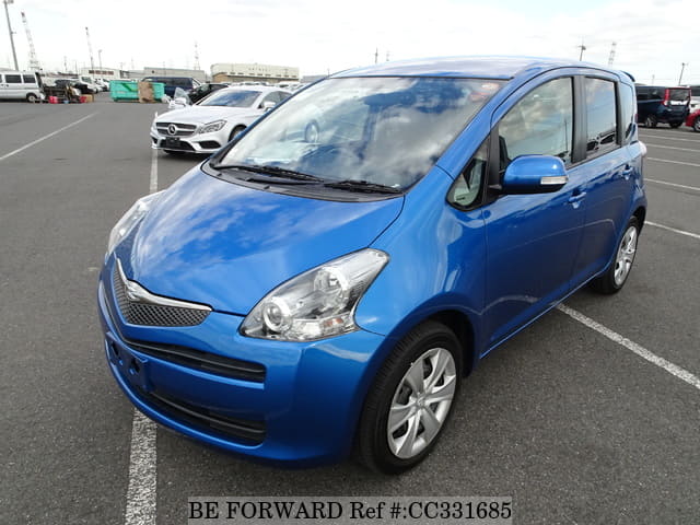 A grey sports car speeding down a highway at night.
