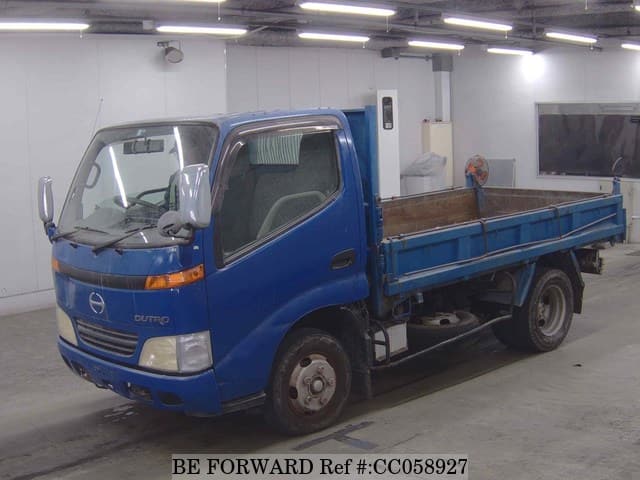 A grey sports car speeding down a highway at night.